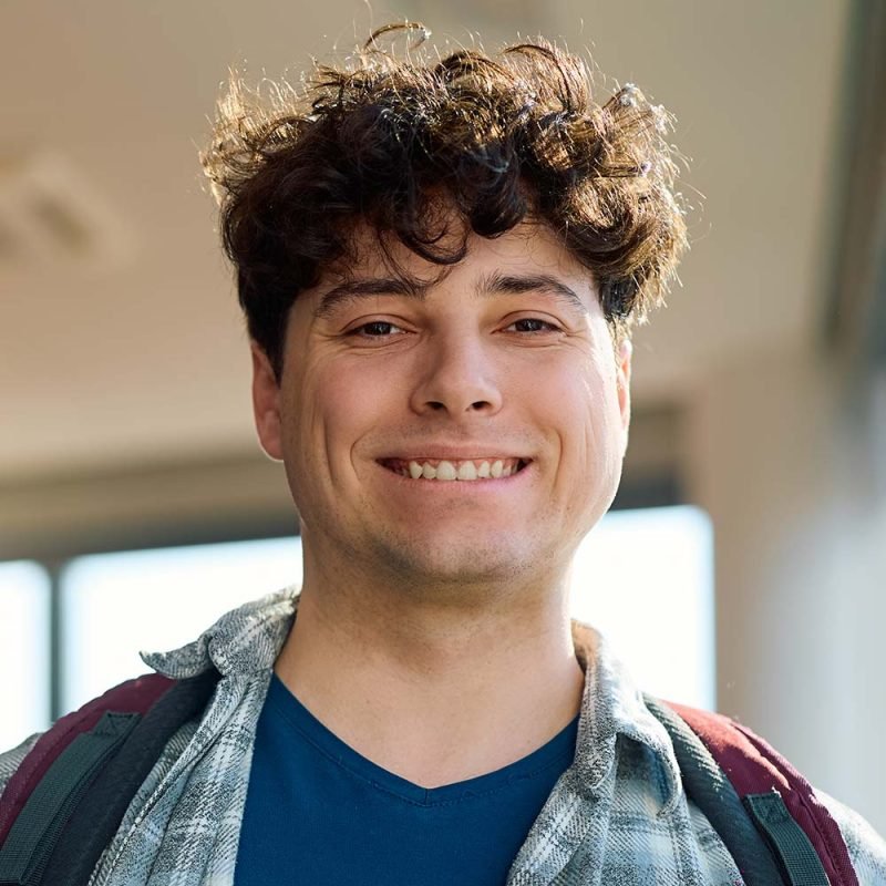 happy-student-at-university-classroom-looking-at-c-TZ5ZT5G-800x800